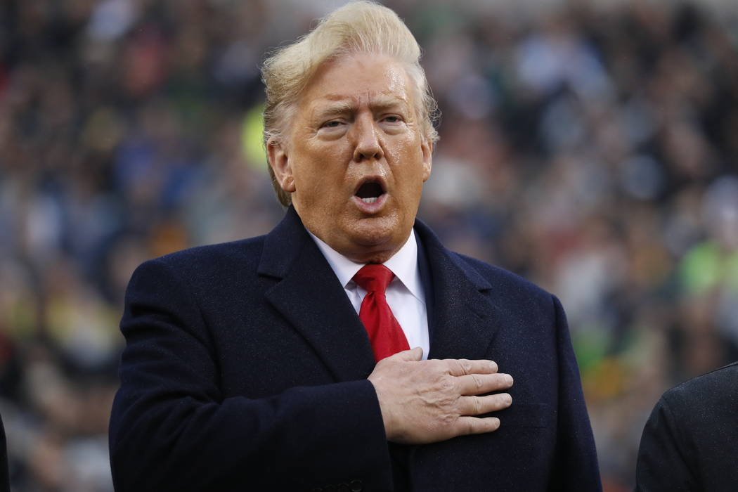 President Donald Trump holds his hand over his heart for the Pledge of Allegiance before the st ...
