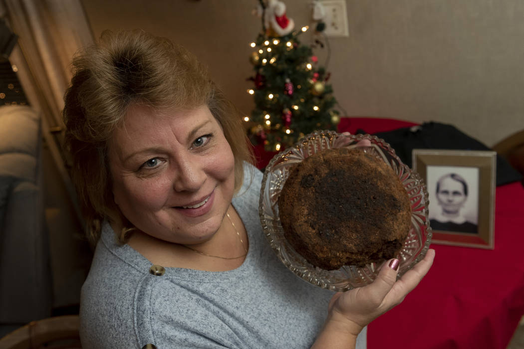 In this Dec. 9, 2019, photo Julie Ruttinger, of Tecumseh, Mich., holds a 141-year-old fruitcake ...