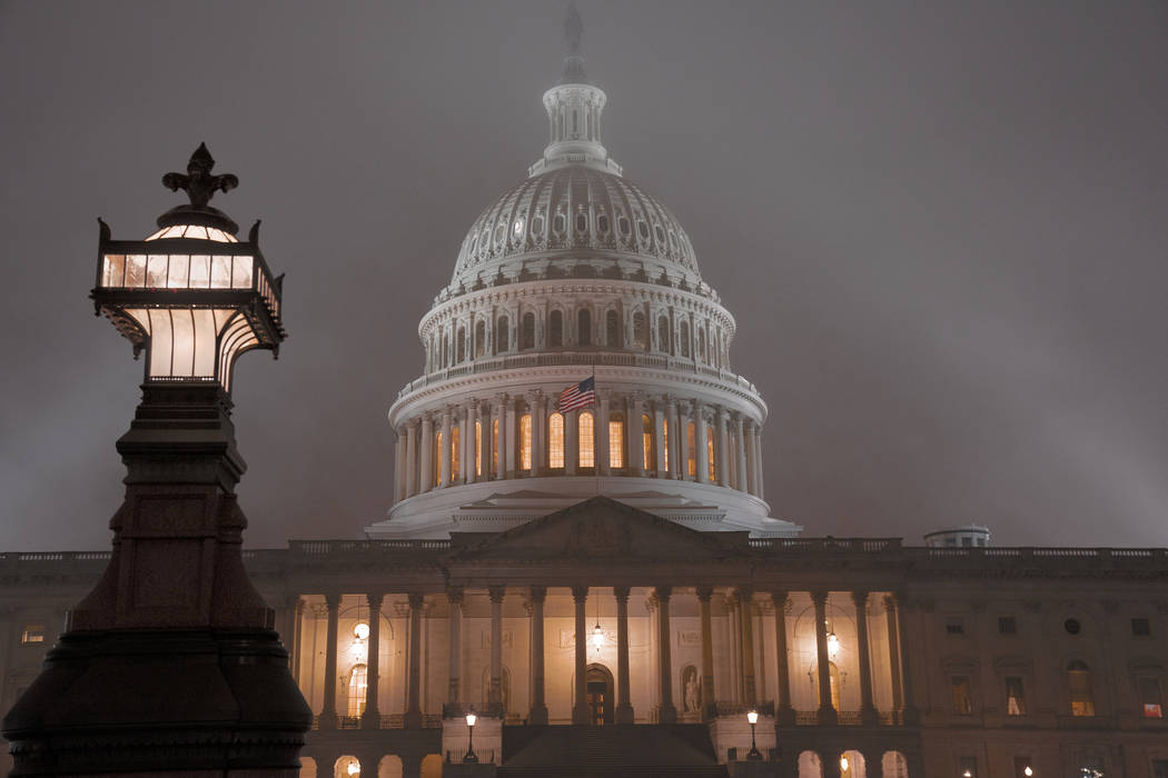 The U.S. Capitol in Washington is shrouded in mist, Friday night, Dec. 13, 2019. This coming w ...