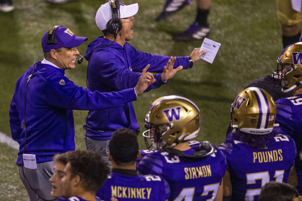 Washington Huskies head coach Chris Petersen, left, directs his players on the sidelines versus ...