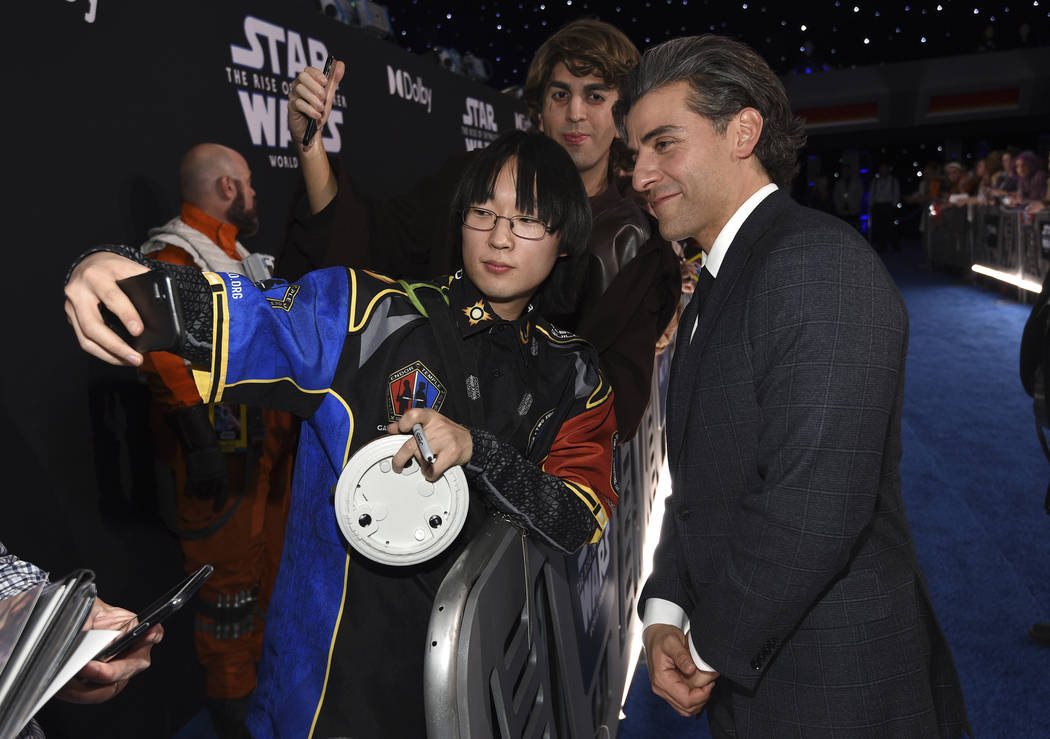 Oscar Isacc, right, takes a selfie with a fan as he arrives at the world premiere of "Star ...