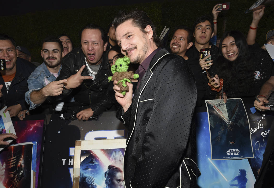 Pedro Pascal holds a baby Yoda doll as poses with fans at the world premiere of "Star Wars ...