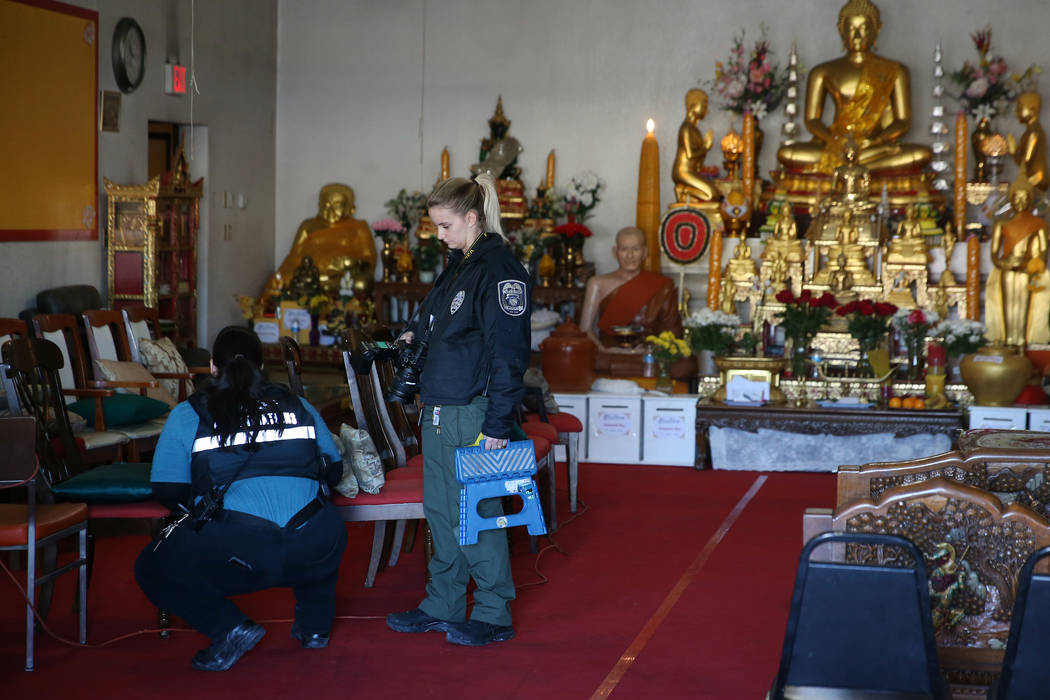 North Las Vegas Police Department crime scene investigators take photos inside the Thai Buddhis ...