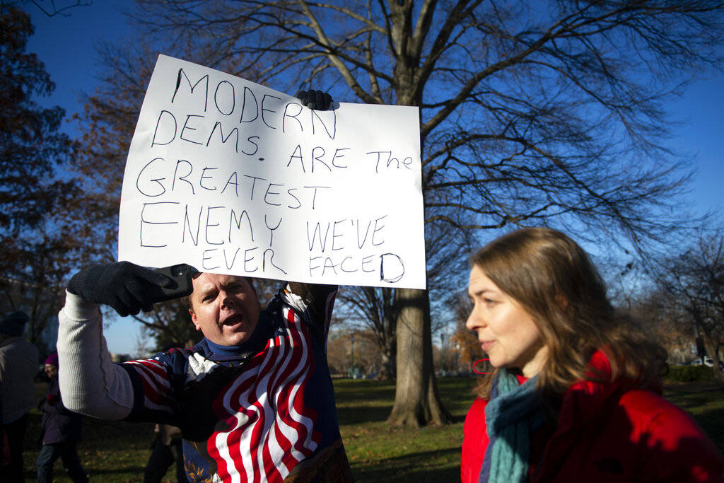 A man against impeachment yells at protestors as they rally in support of the impeachment of Pr ...