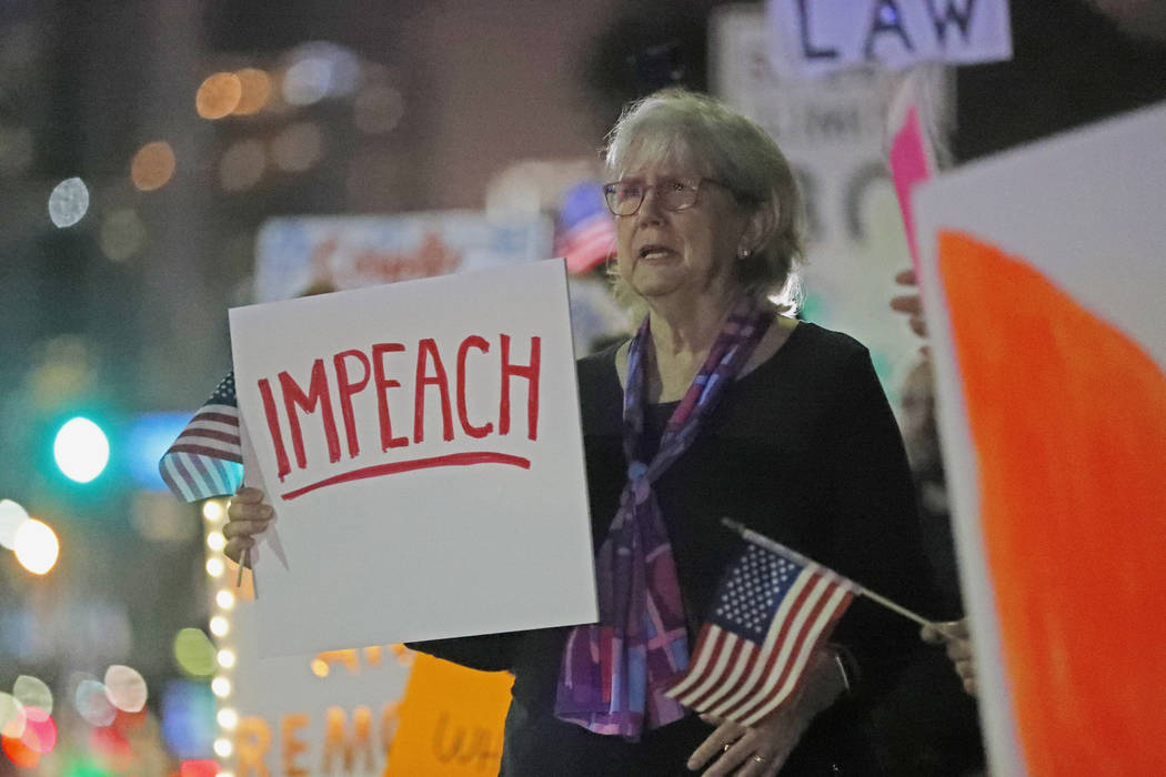 Donna Shelley holds a sign in favor of the impeachment of President Donald Trump, while demonst ...