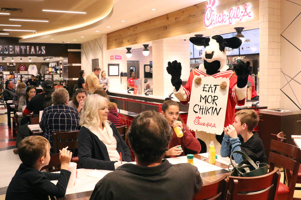 Chick-fil-A's mascot, the cow, greets customers at the first Chick-fil-A restaurant inside the ...