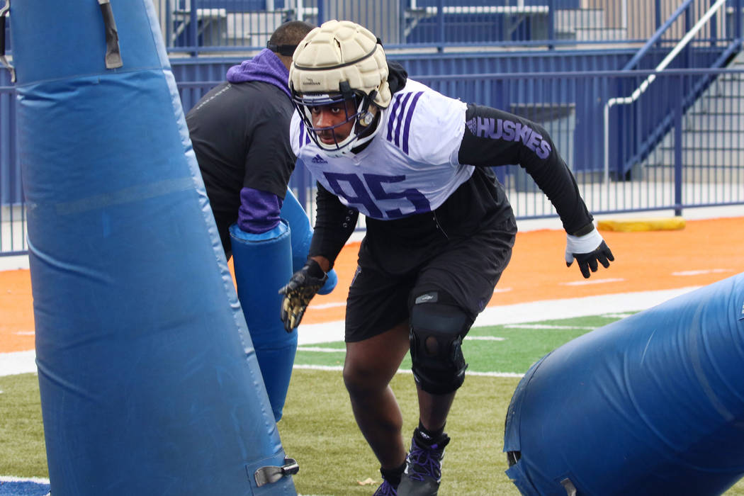 Washington Huskies defensive lineman Levi Onwuzurike attacks tackling dummies during his team ...
