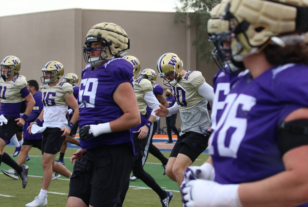 Washington Huskies players, including quarterback Jacob Eason (10), warm up during their team p ...