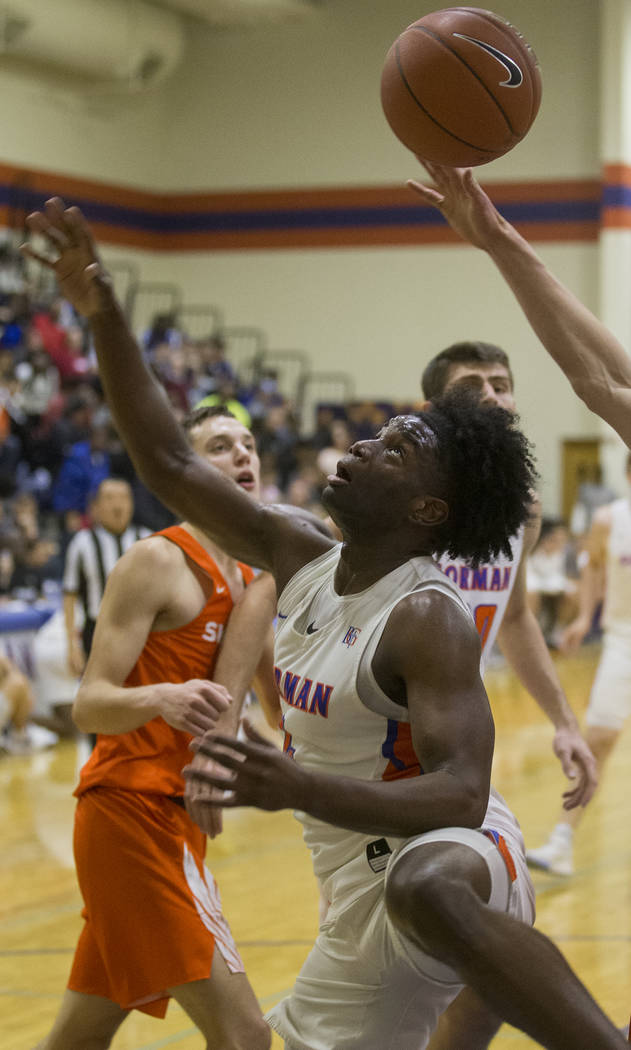 Bishop Gorman junior guard Jonathan Braggs (4) fight for a loose ball in the first half during ...