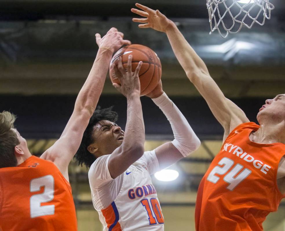 Bishop Gorman junior guard Zaon Collins (10) splits Skyridge defenders Trevon Snoddy (24) and B ...