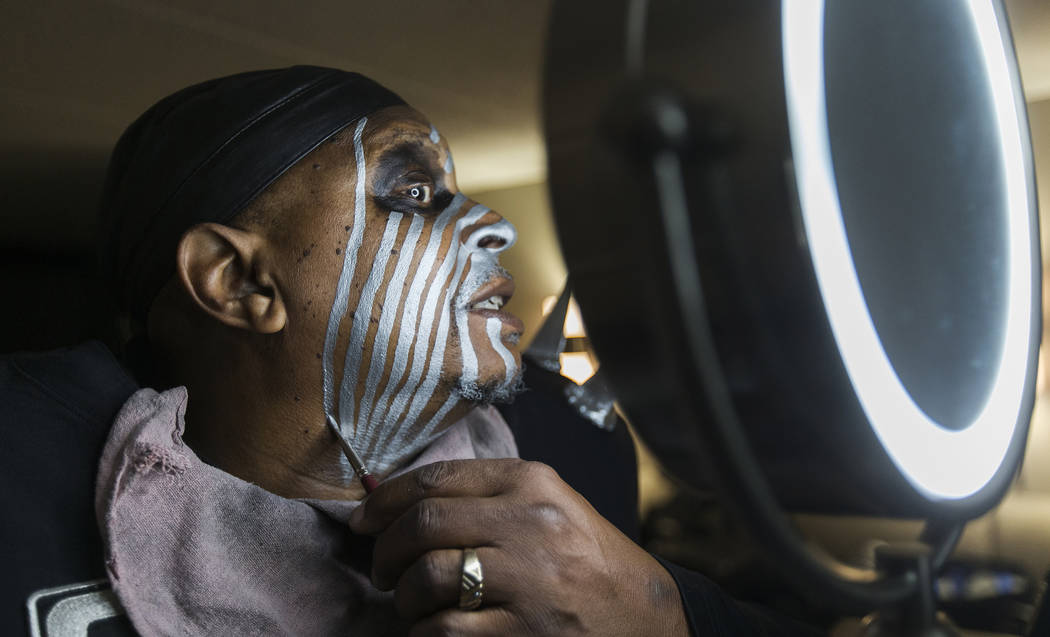 Raiders super fan Wayne Mabry, known as "Violator," applies makeup in his hotel room ...