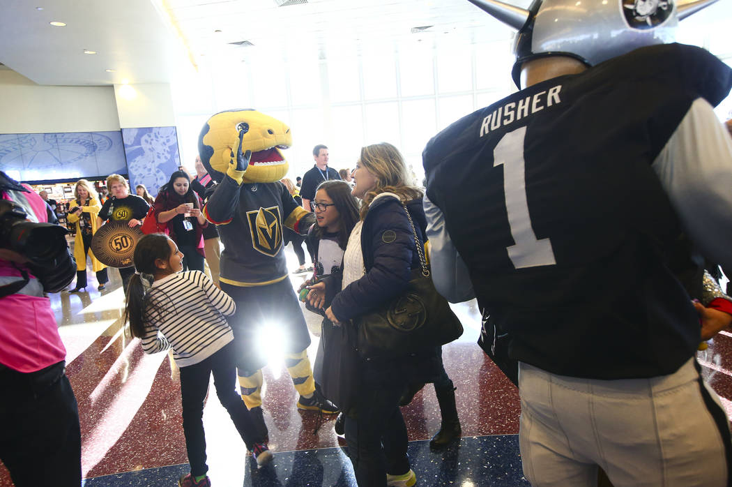 Golden Knights mascot Chance and Raiders mascot Raider Rusher welcome passengers deplaning from ...