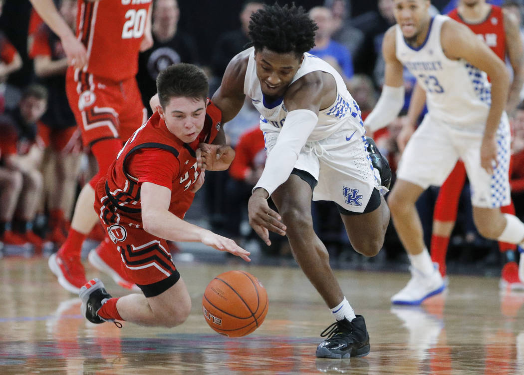 Utah's Rylan Jones, left, and Kentucky's Ashton Hagans scramble for the ball during the second ...