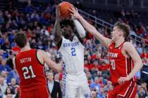 Kentucky's Kahlil Whitney (2) tries to shoot between Utah's Riley Battin, left, and Mikael Jant ...
