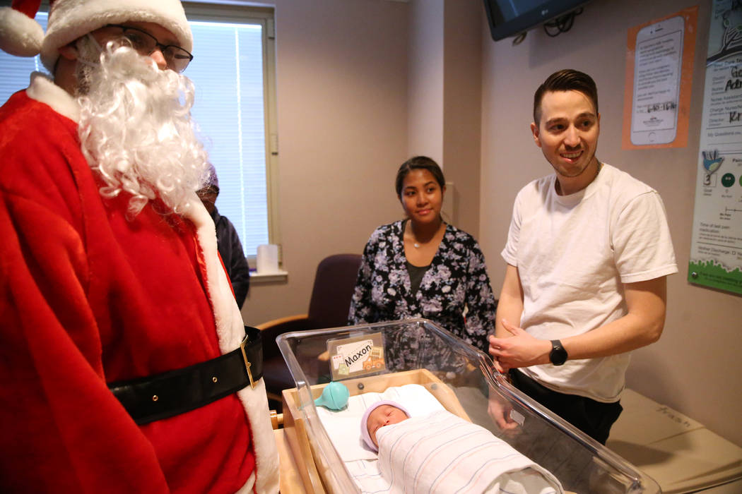 Sheila Cuevas, center, with her husband, Jay Jay, and their newborn son, Maxon, during a visit ...
