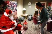 Annie Marinos, right, looks at her 4-month-old daughter, Ashlynn, during a visit from Santa Cla ...