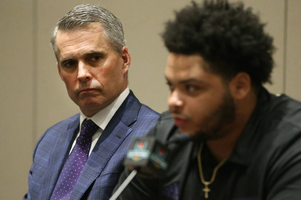 Washington Huskies head coach Chris Petersen, left, looks on at offensive lineman Nick Harris s ...