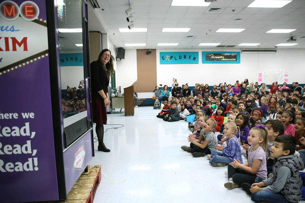 Assistance Principal Michelle Thom looks on with her students as a book vending machine is unve ...