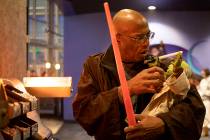 George R. Addison III pretends to feed his Yoda doll at the Star Wars: The Rise of Skywalker pr ...