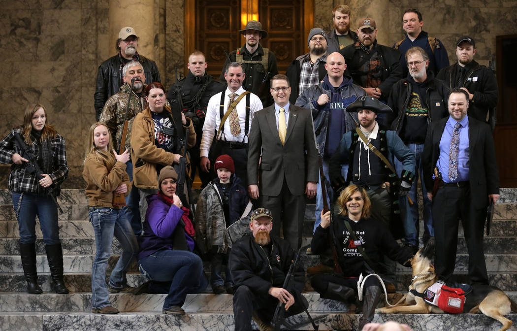 Washington state Rep. Matt Shea, R-Spokane Valley, in suit and yellow tie at center, poses for ...