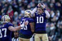 Washington quarterback Jacob Eason, right, celebrates scoring a touchdown with teammates tight ...