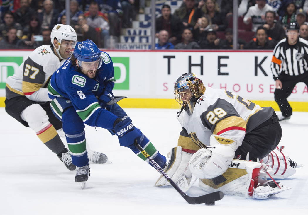 Vancouver Canucks defenseman Christopher Tanev (8) sends the game-winning goal past Vegas Golde ...