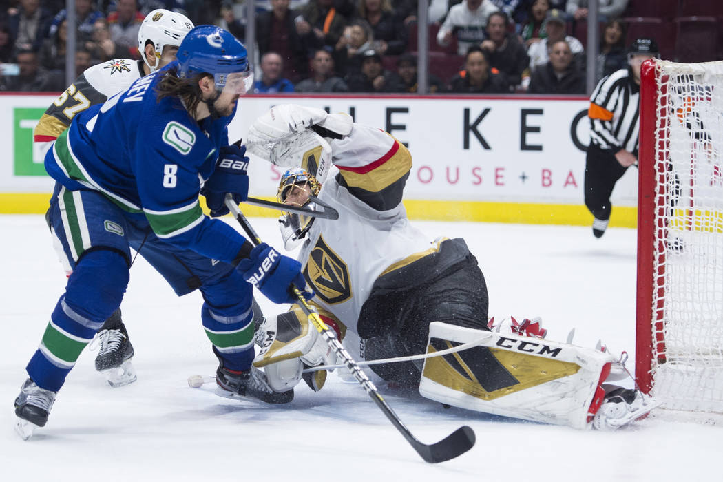 Vancouver Canucks defenseman Christopher Tanev (8) sends the game-winning goal past Vegas Golde ...