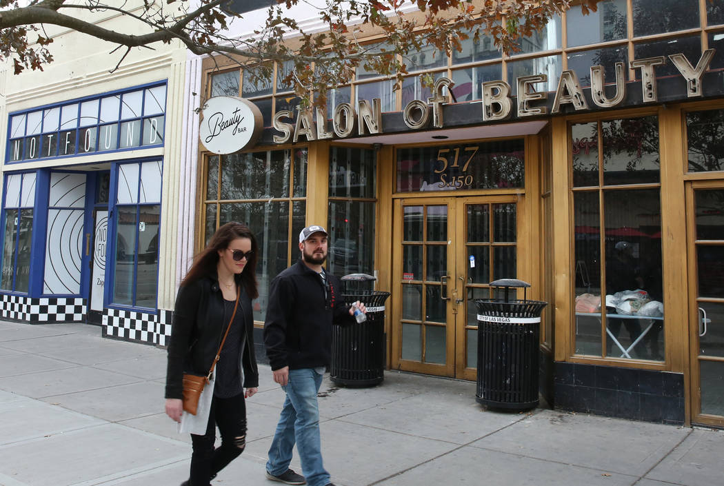 Pedestrians walk past the former Beauty Bar, right, and an unoccupied store, suite no. 110 at 5 ...