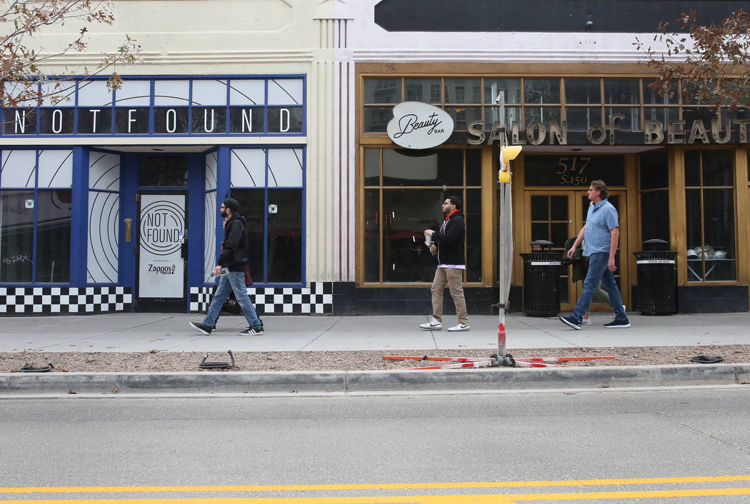 Pedestrians walk past the former Beauty Bar, right, and an unoccupied store, suite no. 110 at 5 ...