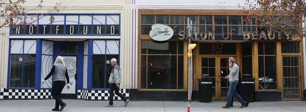 Pedestrians walk past the former Beauty Bar, right, and an unoccupied store, suite no. 110 at 5 ...