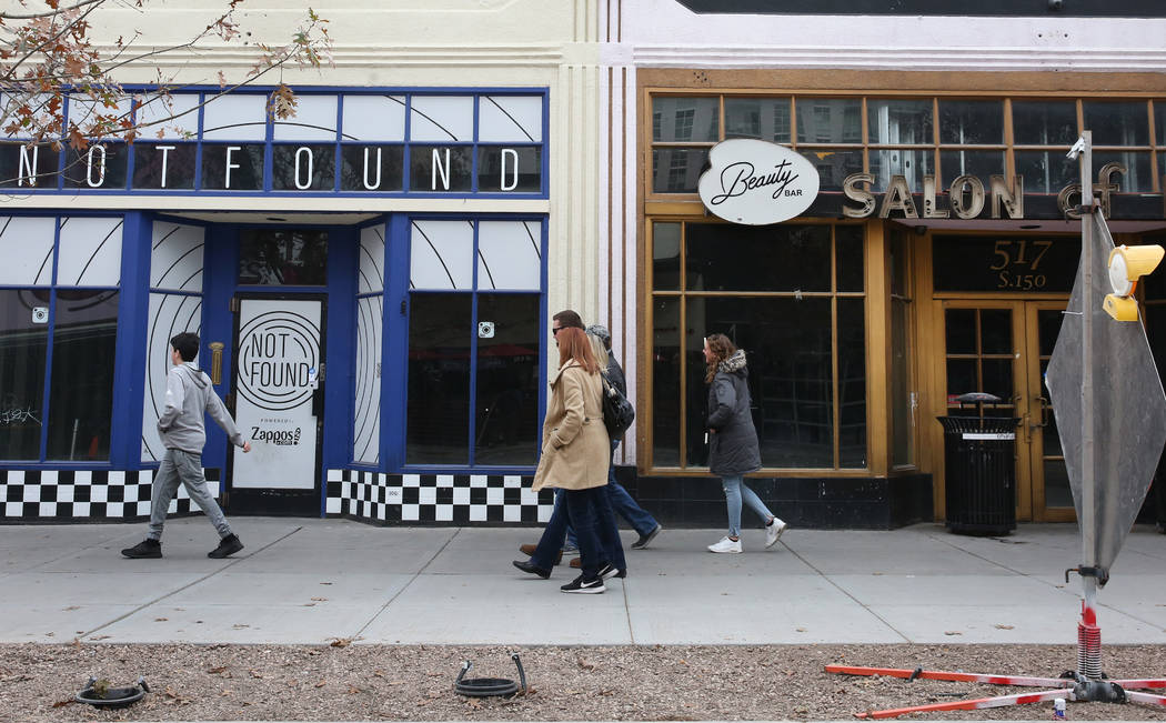 Pedestrians walk past the former Beauty Bar, right, and an unoccupied store, suite no. 110 at 5 ...