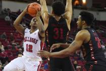 Fresno State's Mustafa Lawrence, left, goes up blocked by UNLV's Marvin Coleman, center, and Ni ...