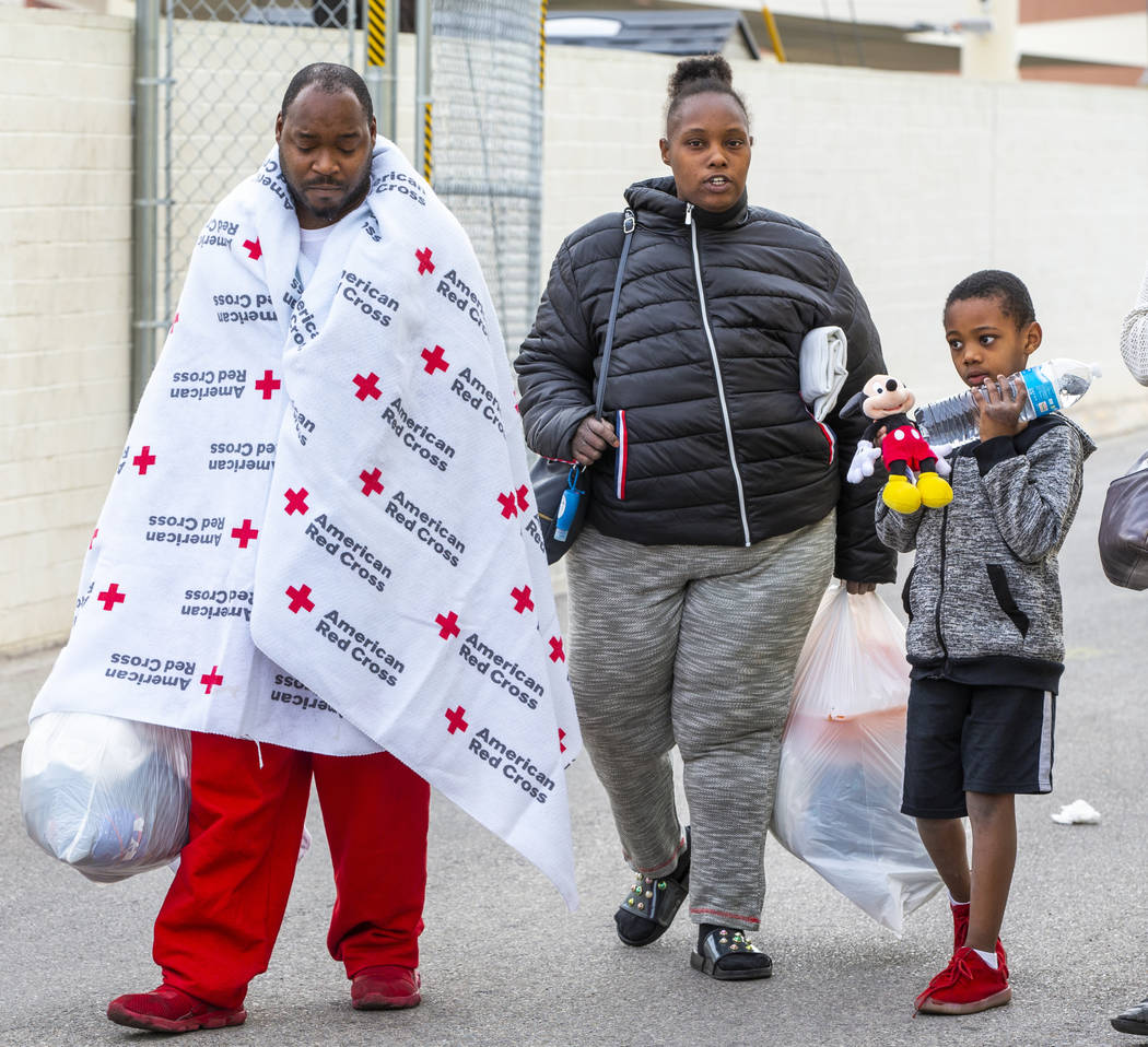 Alpine Motel Apartments residents Jimmy Lacy, left, Dayshena Thomas and Andru Roach, 7, depart ...