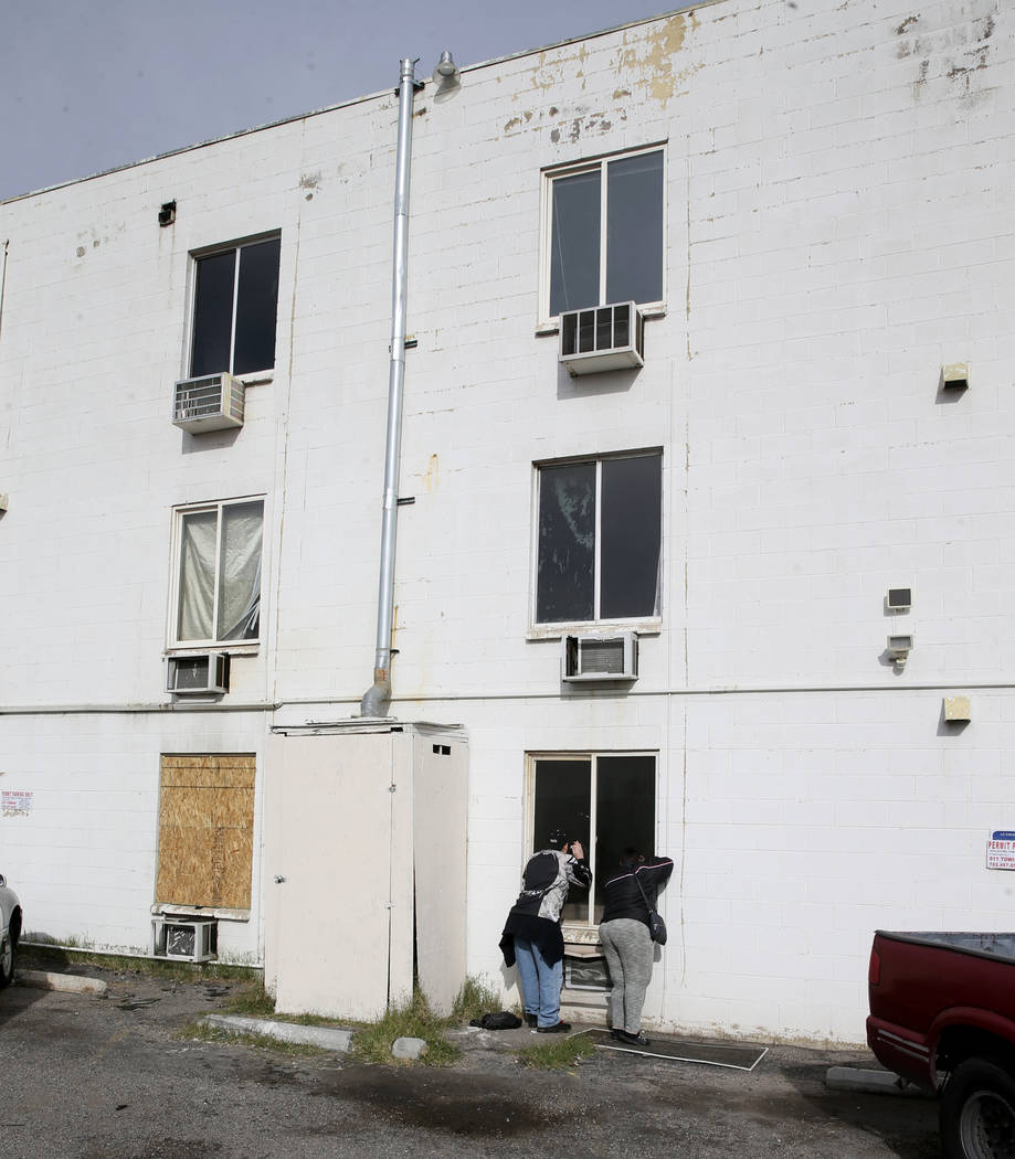 Residents gather at Alpine Motel Apartments after a fire left 6 dead and 13 injured at the down ...