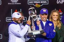 Washington Huskies head coach Chris Petersen, center, and incoming head coach Jimmy Lake, left, ...