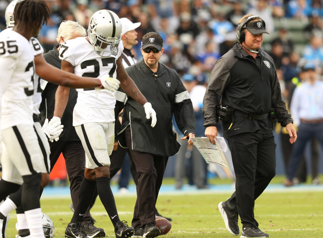 Oakland Raiders cornerback Trayvon Mullen (27) comes off the field, led by head coach Jon Grude ...