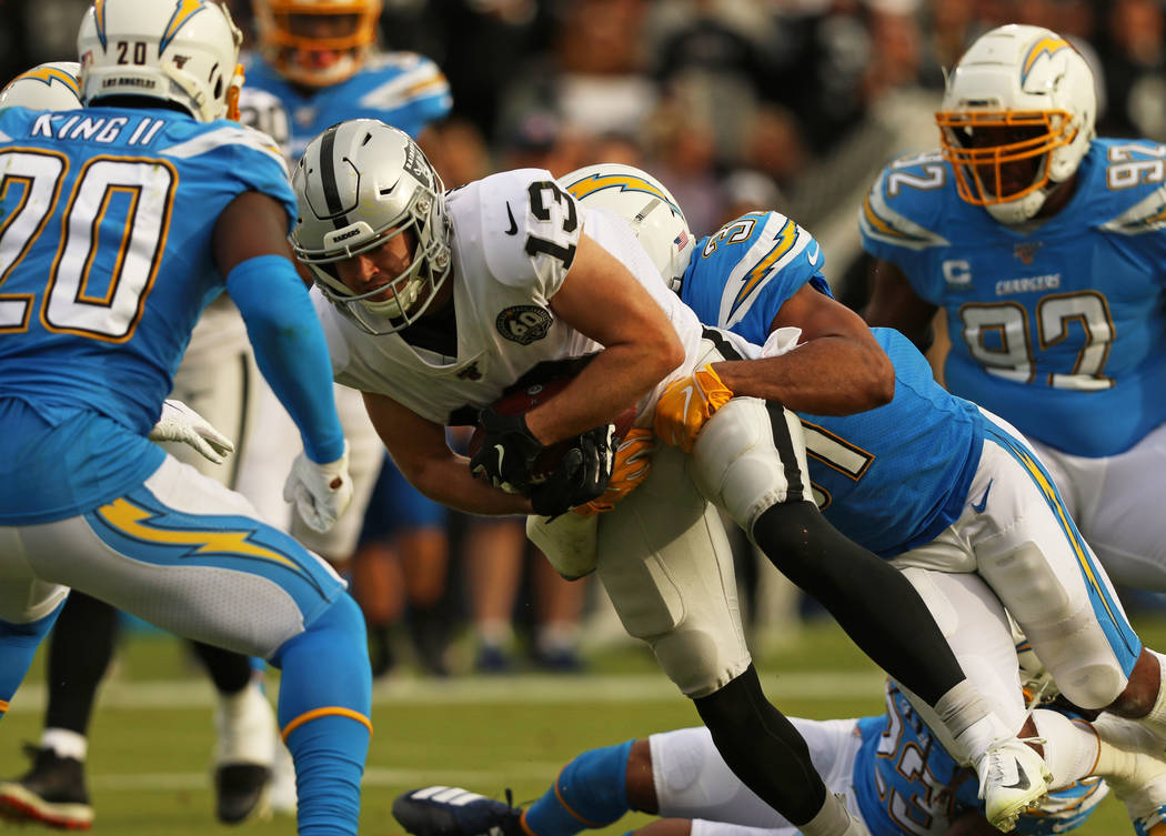 Oakland Raiders wide receiver Hunter Renfrow (13) holds on to the football as he is tackled by ...