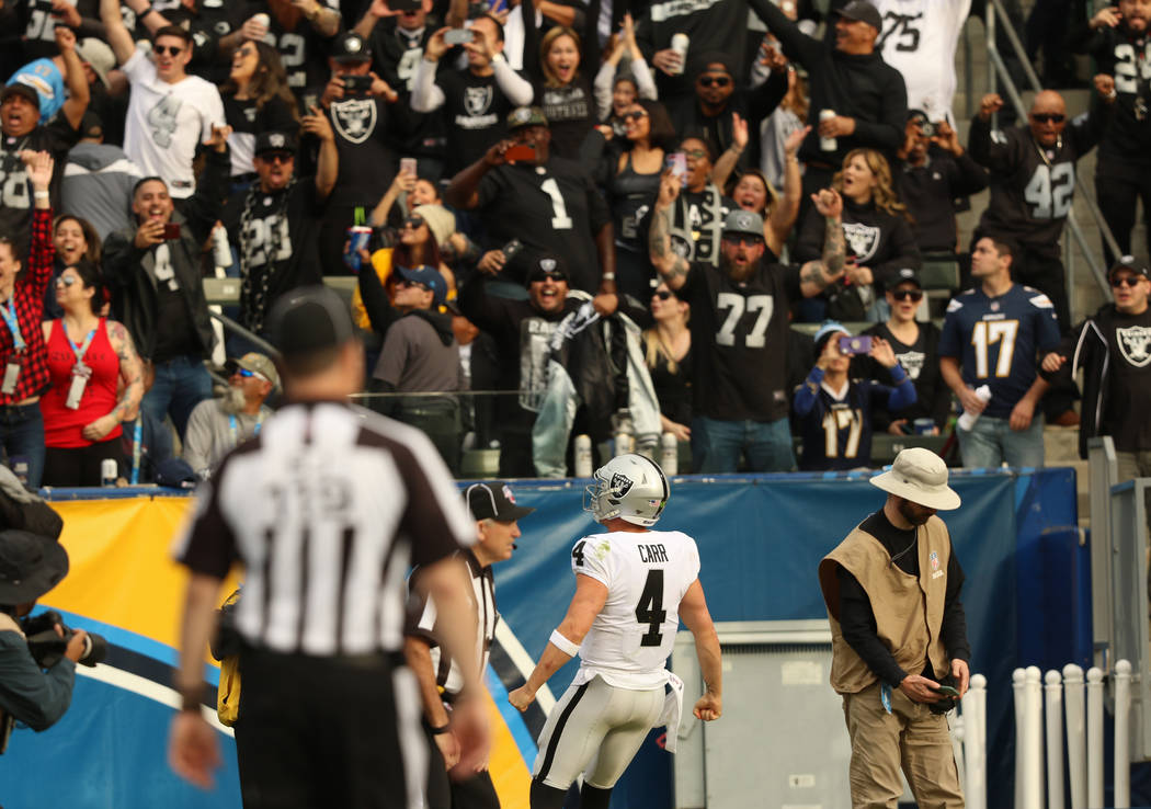 Oakland Raiders quarterback Derek Carr (4) celebrates his touchdown as the crowd cheers during ...
