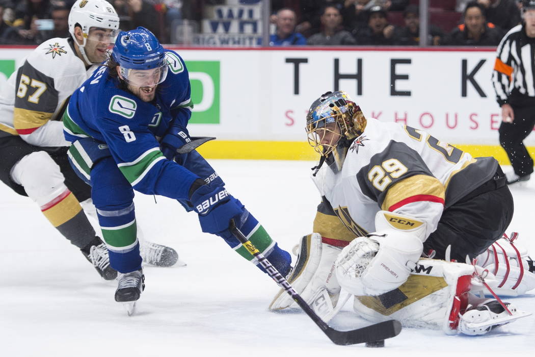 Vancouver Canucks defenseman Christopher Tanev (8) sends the game-winning goal past Vegas Golde ...