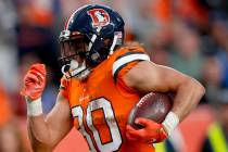 Denver Broncos running back Phillip Lindsay (30) breaks free from the grasp of Detroit Lions li ...