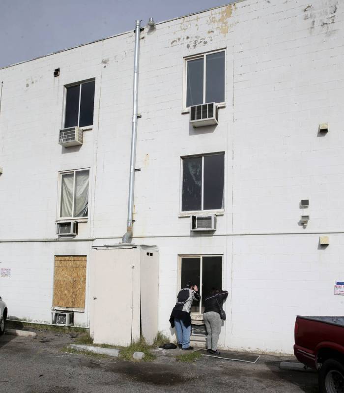 Residents gather at Alpine Motel Apartments after a fire left 6 dead and 13 injured at the down ...