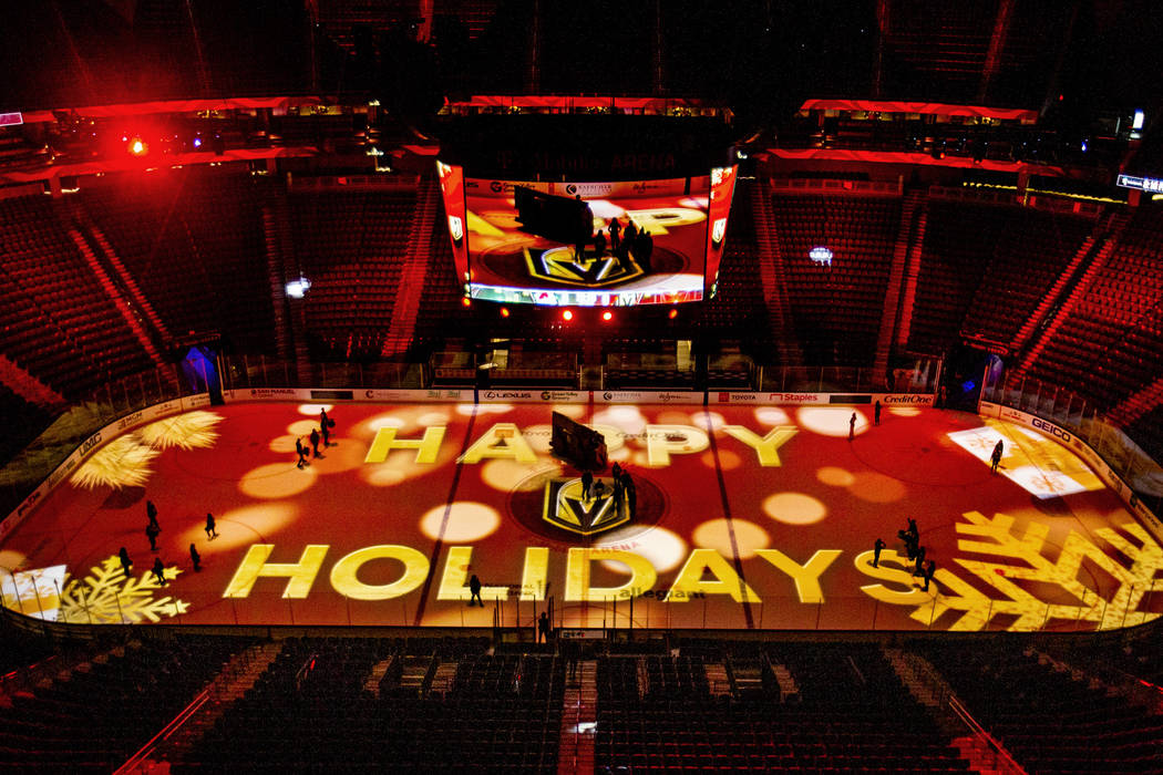 Happy holidays is projected onto the ice during a rehearsal for the Vegas Golden Knights holida ...