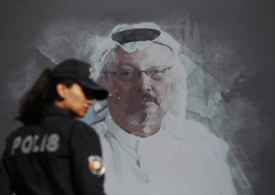 FILE - In this Oct. 2, 2019 file photo, a Turkish police officer walks past a picture of slain ...