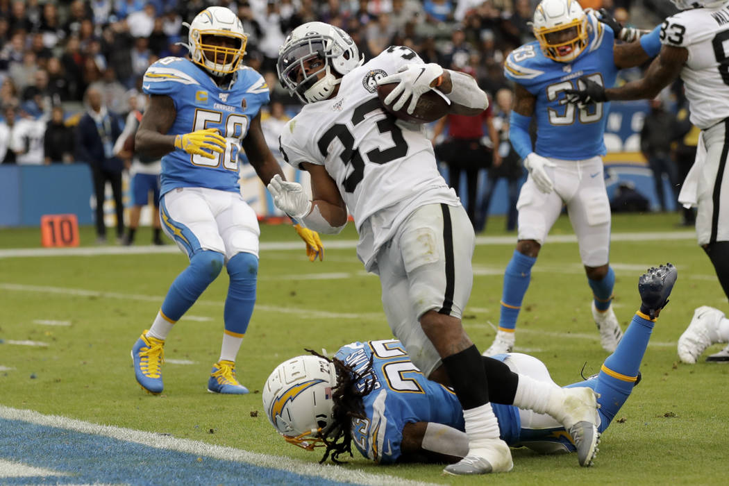 Oakland Raiders running back DeAndre Washington, right, scores past Los Angeles Chargers strong ...