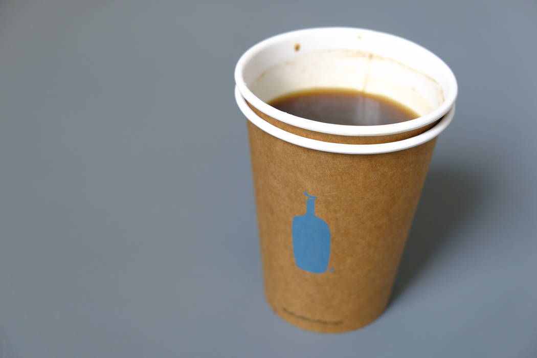 In this Thursday, Dec. 12, 2019 photo, a Blue Bottle Coffee paper to-go cup rests on a table ou ...