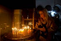 A visitor lights a candle at the Church of the Nativity built on top of the site where Christia ...