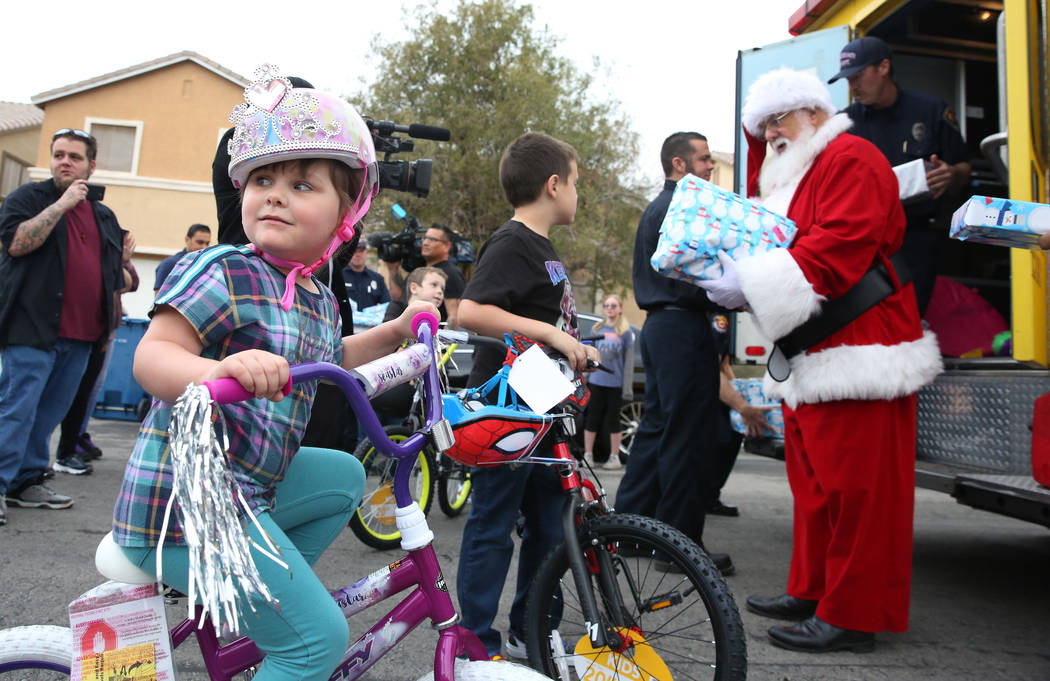 Aria Runyan, 4, tries out her new bike after Santa delivered her presents outside of her Las Ve ...