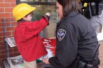 Bailey Stacey, 3, helps Oxford (Miss.) Police Officer Rachel Ratcliffe solve a Christmas caper. ...