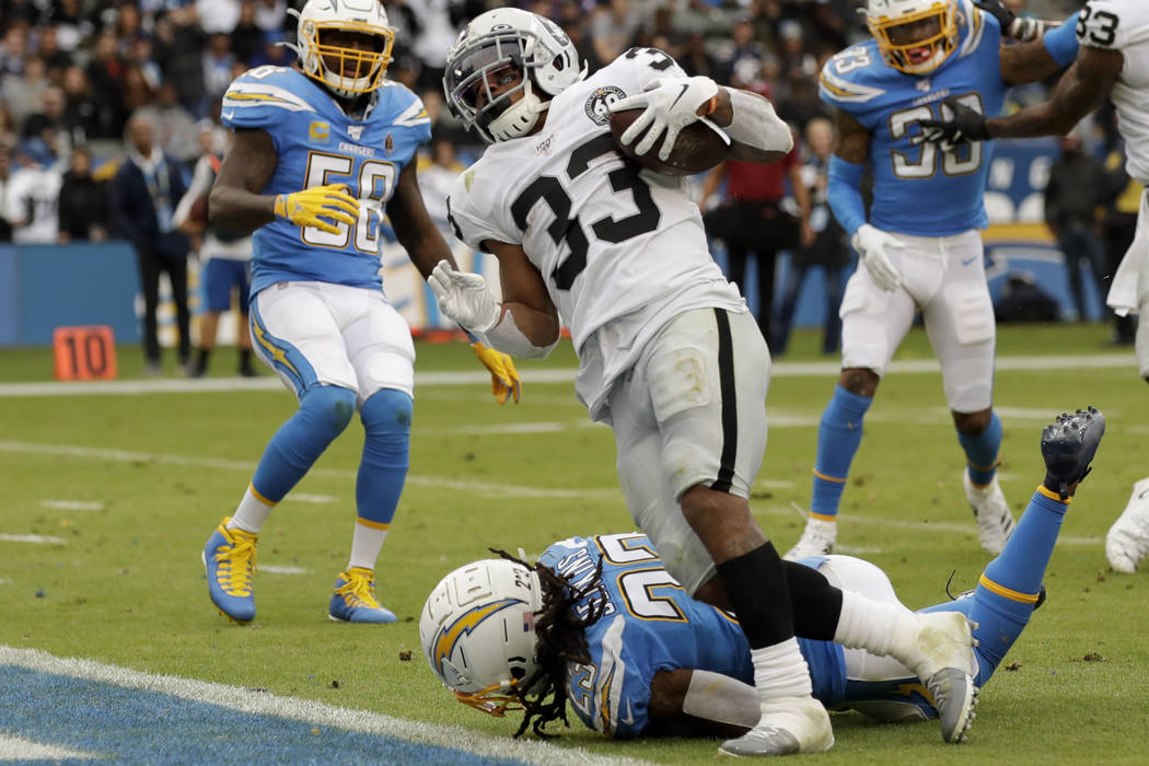 Oakland Raiders running back DeAndre Washington, right, scores past Los Angeles Chargers strong ...