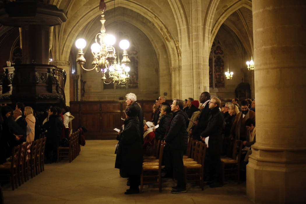 Believers the christmas mass, in Saint-Germain l'Auxerrois church, in Paris, Tuesday, Dec. 24, ...